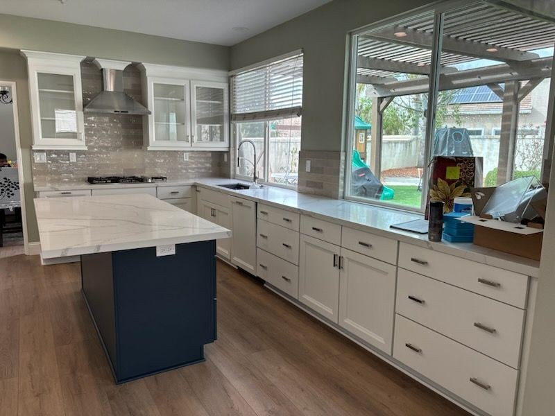 Kitchen remodel with white cabinets and blue island