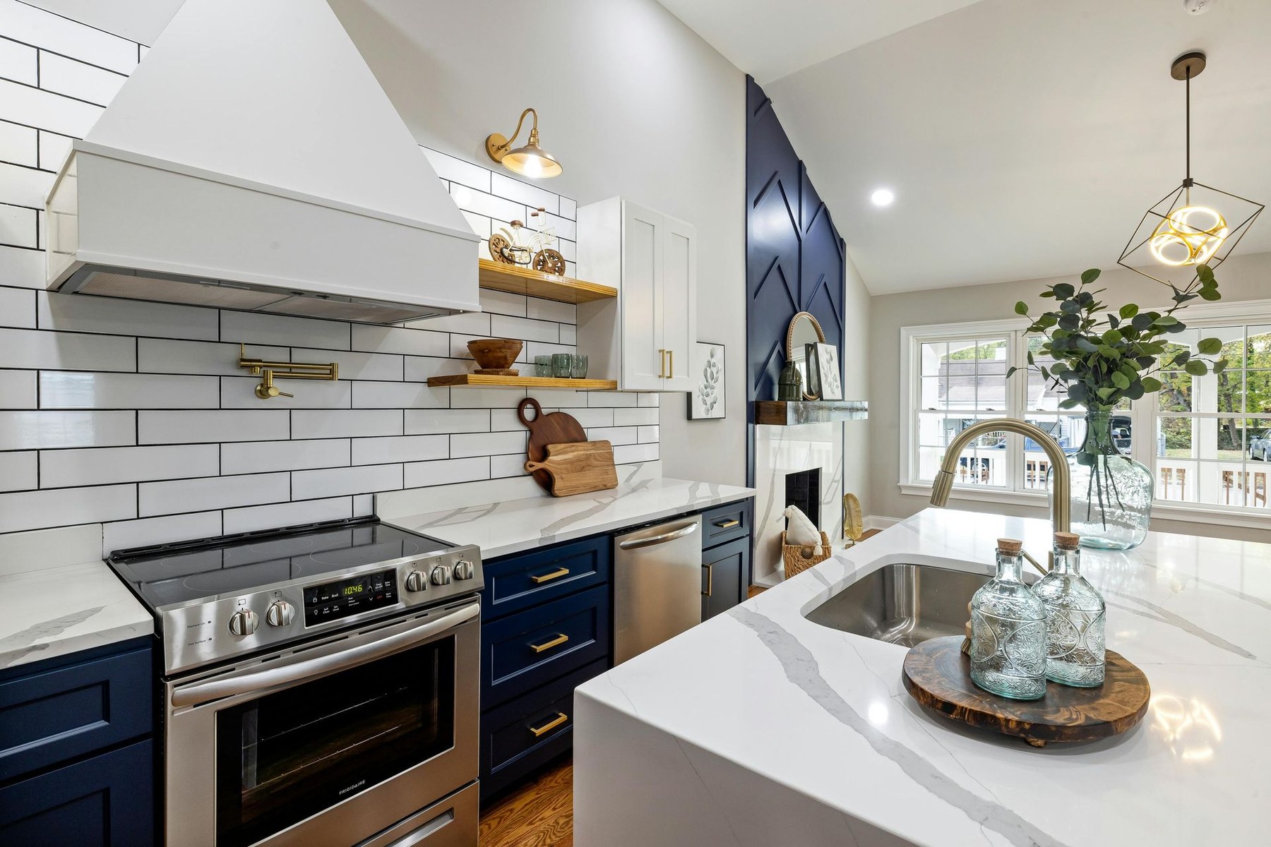 Open white kitchen remodel with island and upgraded lighting